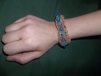 beaded bracelet made from tan plastic bags and blue glass beads