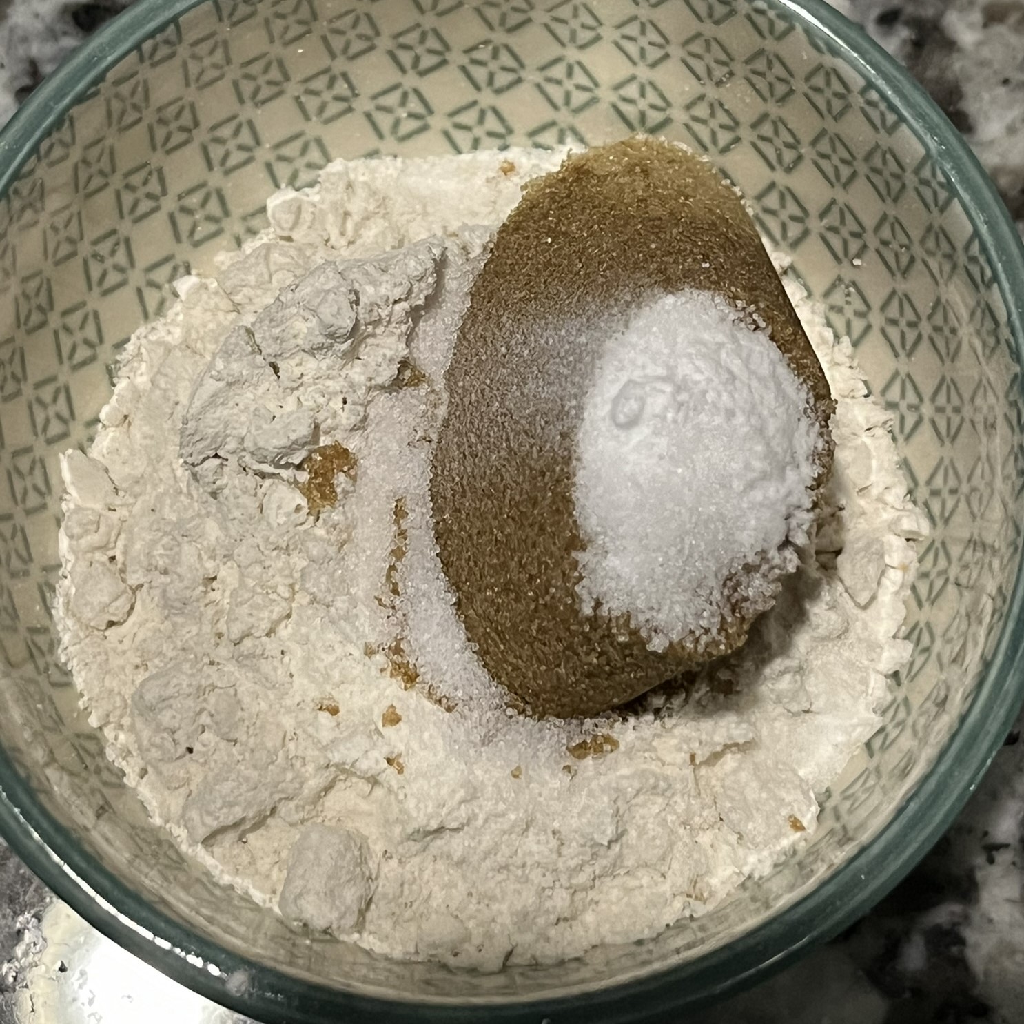 small, green and white ceramic bowl with flour, brown sugar, baking soda, and salt in it