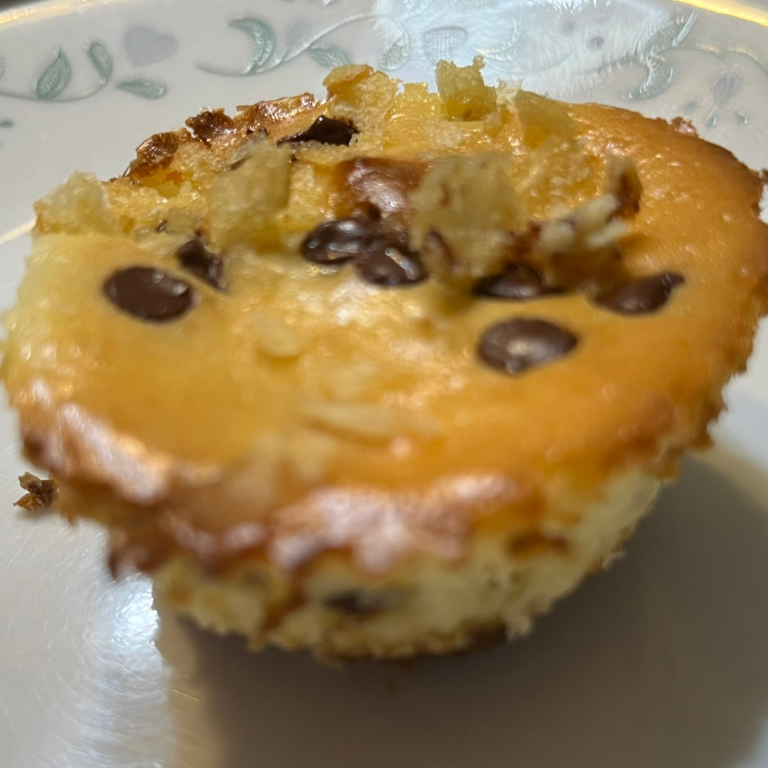 chocolate chip cheesecake with a broken chip cookie for a crust and crushed potato chips dusted on top, on a white plate