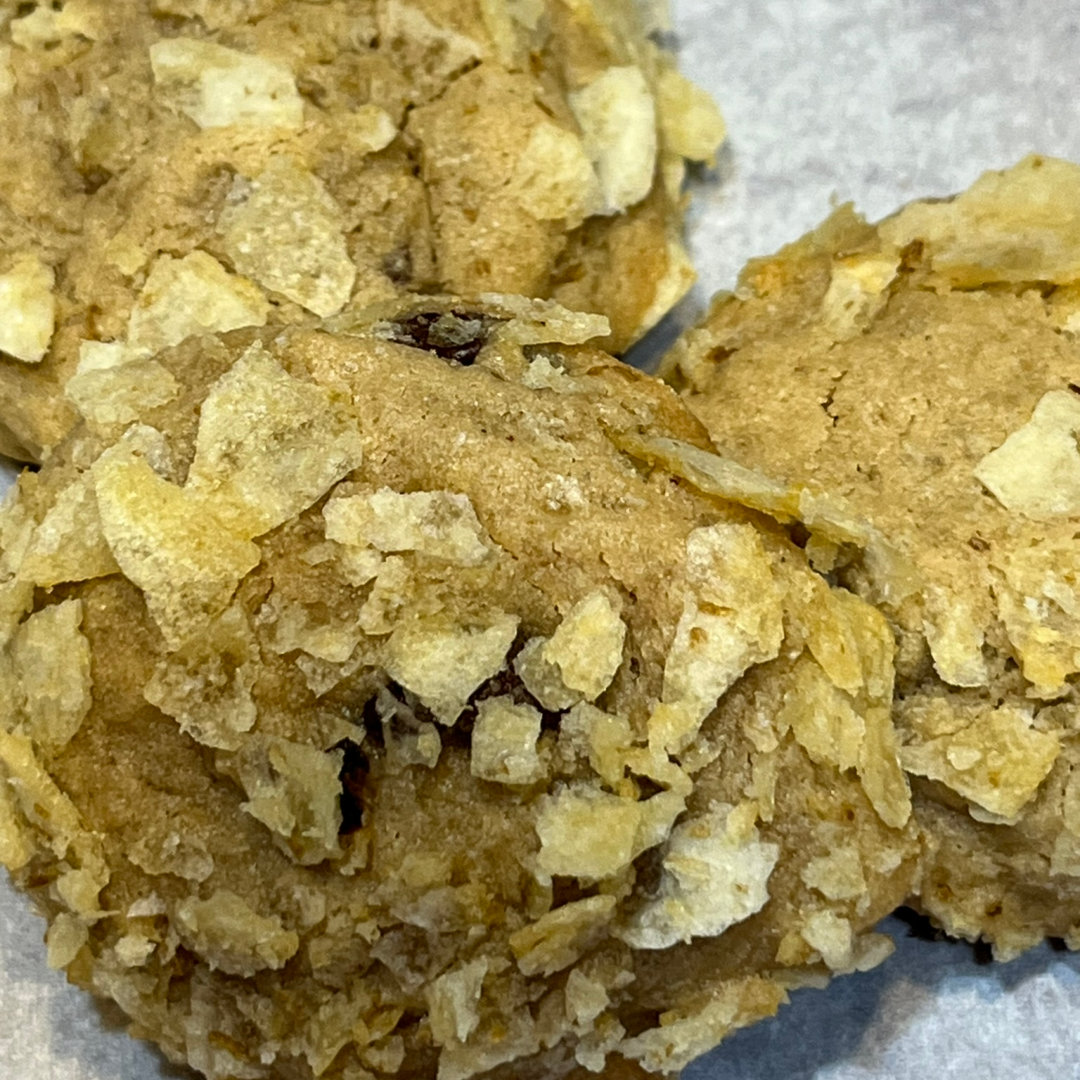 chocolate chip cookies coated with crushed potato chips on a white plate